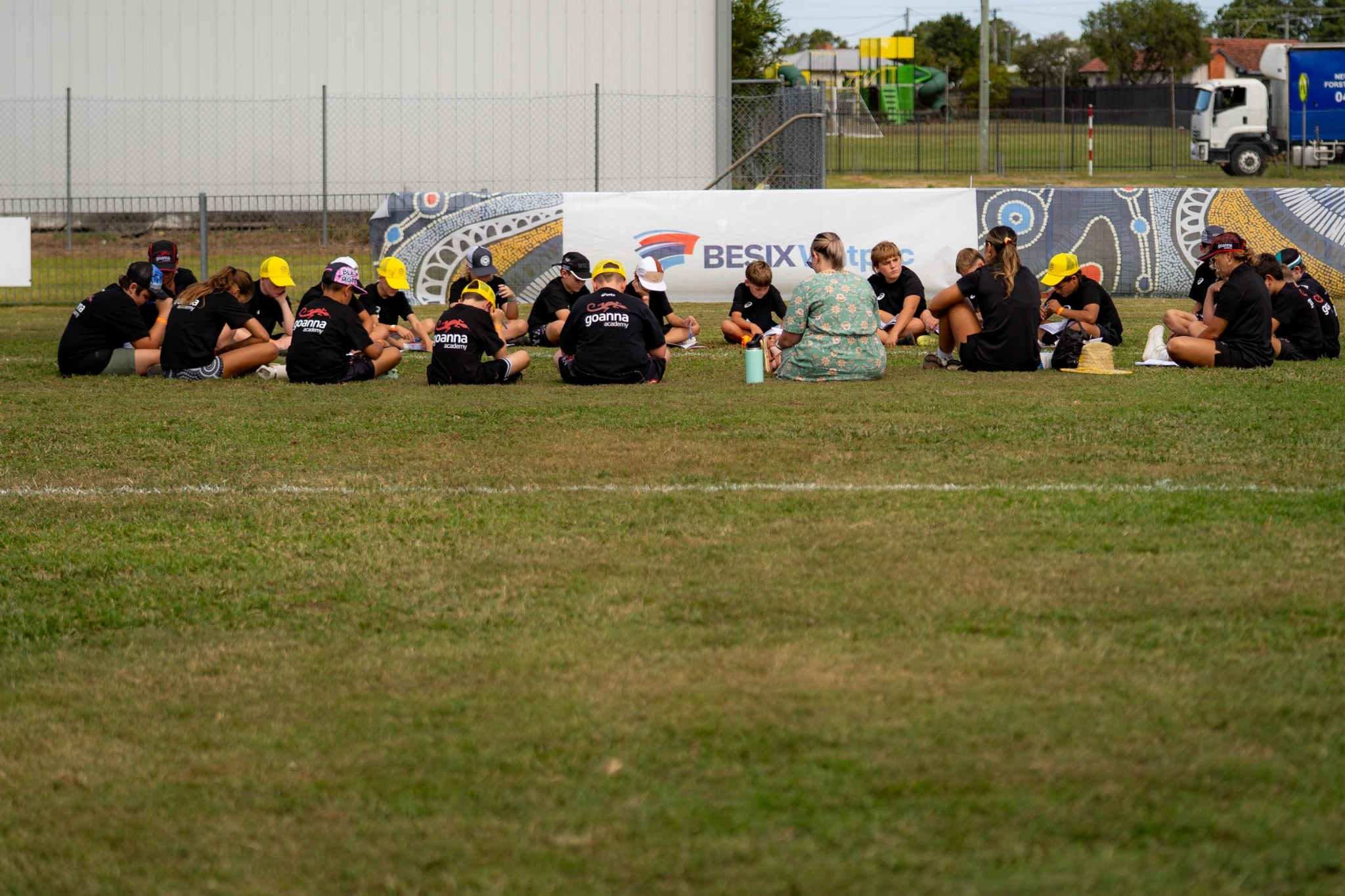 Kids yarning and listening on the field